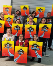 A group of people holding up hand-painted canvases featuring a cartoon emu character with a yellow and orange gradient background.