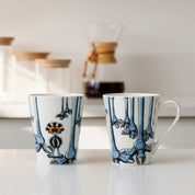 Two ceramic mugs with decorative patterns on a white background