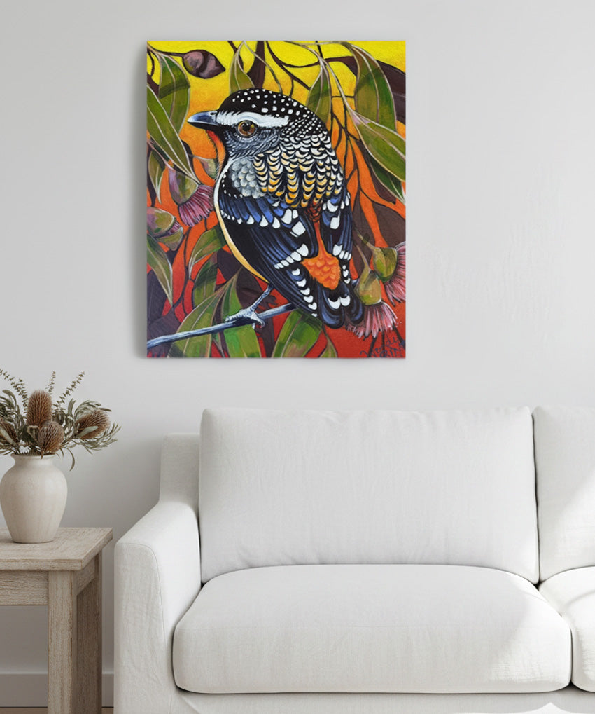 Colorful bird painting on a wall above a white sofa